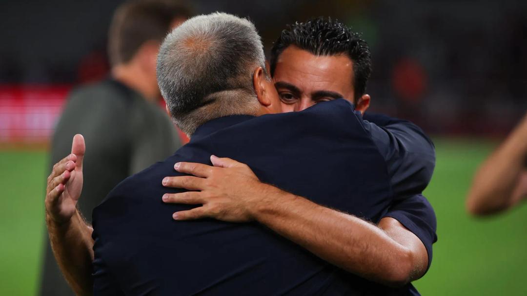 Xavi Hernandez hugs President Joan Laporta