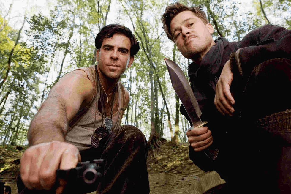 Brad Pitt with a knife in hand and crouching down in Inglourious Basterds
