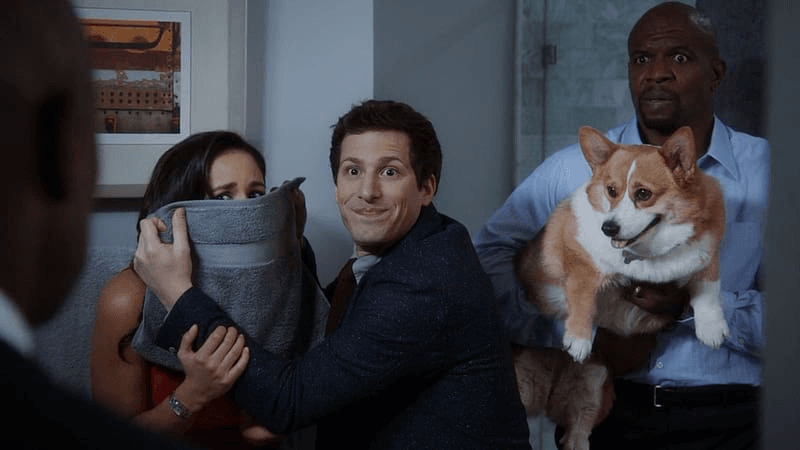 Jake holding pillow over Amy while Terry holds Cheddar the Dog