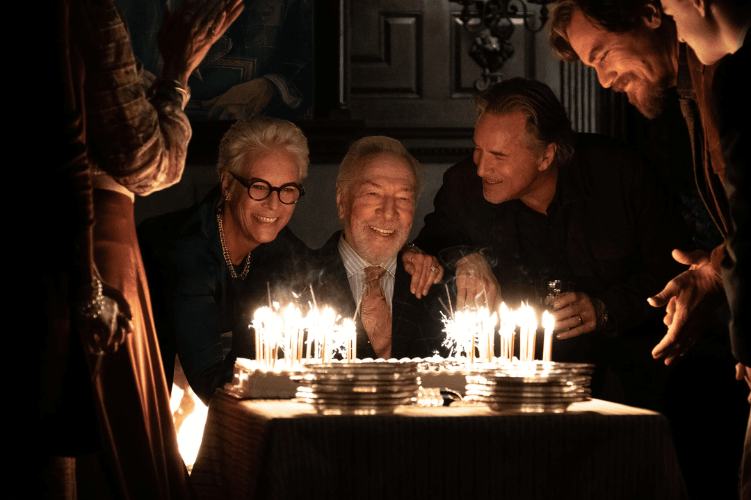 Three characters looking at a cake and smiling